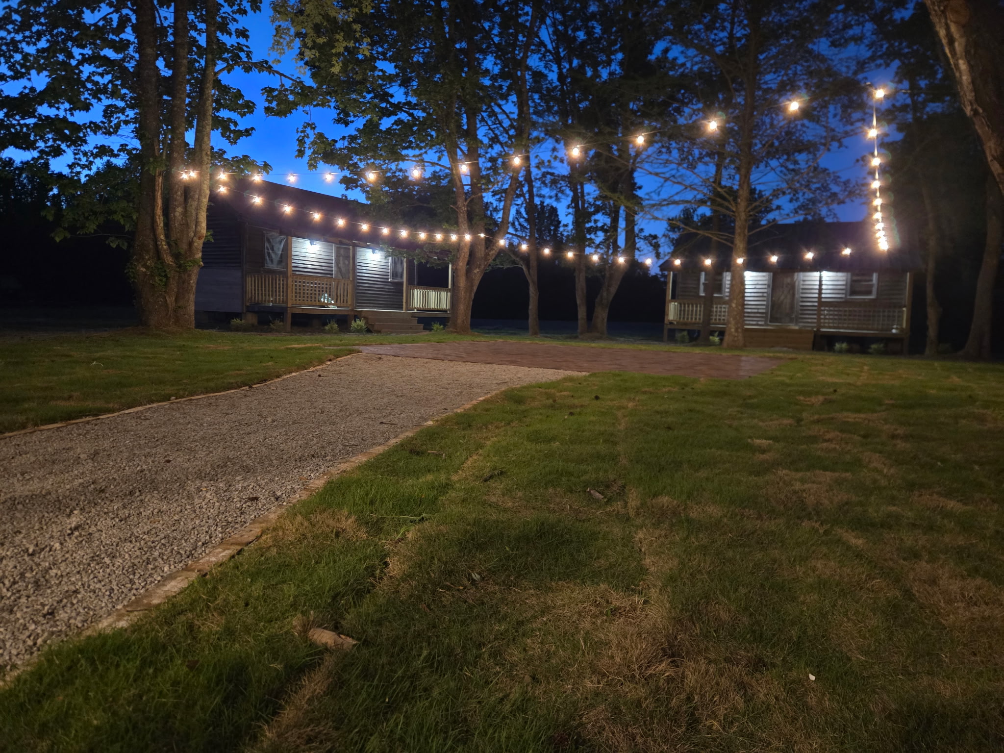 Cabins lit at twilight beneath strung bistro lights