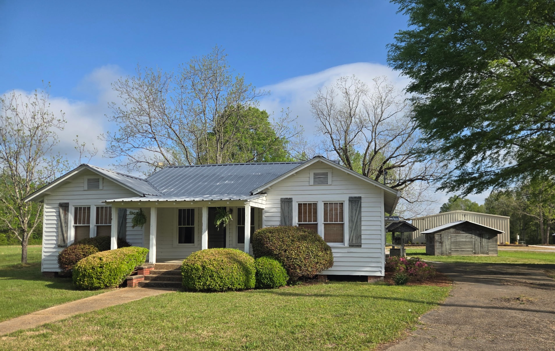 White cottage with porch on the property grounds